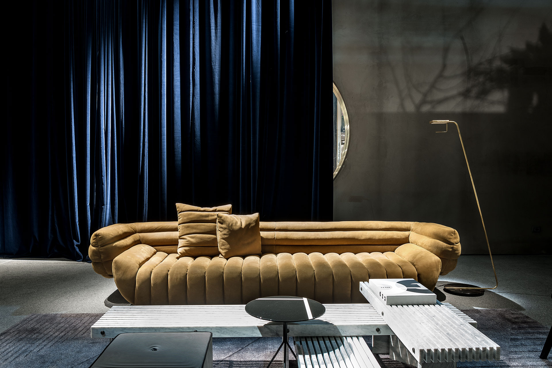 BAXTER Sofa gold vor blauem Vorhang